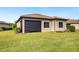 Tan house exterior with a black awning and manicured lawn at 5987 Snowy Egret Dr, Sarasota, FL 34238