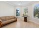 Bright living room featuring hardwood floors, large windows with plantation shutters, and a comfortable couch at 5987 Snowy Egret Dr, Sarasota, FL 34238