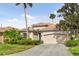 Tan one-story house with a two-car garage and palm trees at 9143 Willow Brook Dr, Sarasota, FL 34238