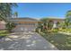 Two-car garage and long driveway with lush landscaping at 4978 Cedar Oak Way, Sarasota, FL 34233