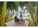 A beautiful backyard featuring a dining set, outdoor seating, and lush landscaping at 745 Bruce Ave, Clearwater Beach, FL 33767