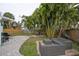 Backyard featuring mature palms, an outdoor dining area, and comfortable wicker patio furniture at 745 Bruce Ave, Clearwater Beach, FL 33767
