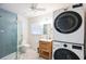 Modern bathroom featuring a glass-enclosed shower, stacked washer/dryer, and stylish vanity at 745 Bruce Ave, Clearwater Beach, FL 33767