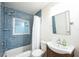 Updated bathroom featuring blue tiled walls, a window for natural light, and a modern vanity at 745 Bruce Ave, Clearwater Beach, FL 33767