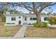 Charming home featuring a lovely paver walkway, mature tree, and freshly painted exterior at 745 Bruce Ave, Clearwater Beach, FL 33767