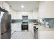 Modern kitchen featuring white cabinets, stainless steel appliances, and granite countertops at 745 Bruce Ave, Clearwater Beach, FL 33767