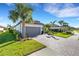 Single-story home with gray garage door, paver driveway, and lush landscaping at 5397 Bartolomeo St, Sarasota, FL 34238