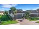 Single-story home with gray garage door, paver driveway, and lush landscaping at 5397 Bartolomeo St, Sarasota, FL 34238