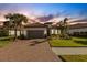 Beautiful home at sunset with a brick driveway at 5397 Bartolomeo St, Sarasota, FL 34238