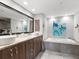 Elegant bathroom with double sinks, soaking tub, and walk-in shower at 1211 Gulf Of Mexico Dr # 408, Longboat Key, FL 34228