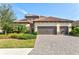 Two-story house with tile roof, three-car garage, and landscaped front yard at 13021 Indigo Way, Bradenton, FL 34211