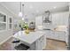 Modern kitchen with white cabinets, large island, and stainless steel appliances at 13021 Indigo Way, Bradenton, FL 34211