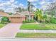 Single-story home with tile roof, landscaping, and brick driveway at 6600 Deering Cir, Sarasota, FL 34240