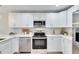 Modern kitchen with white cabinets, stainless steel appliances, and an island at 1006 Hagle Park Rd, Bradenton, FL 34212