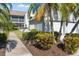 Well-maintained condo building with lush landscaping and walkway at 6713 Stone River Rd # 104, Bradenton, FL 34203