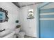 Small bathroom with blue tile shower and nautical decor at 7146 Territory Ln, Sarasota, FL 34240