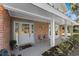 Inviting front porch with brick columns and a gray door at 7146 Territory Ln, Sarasota, FL 34240