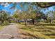 Landscaped yard with long driveway leading to home at 7146 Territory Ln, Sarasota, FL 34240