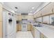 Galley style kitchen with white appliances and light wood cabinets at 7146 Territory Ln, Sarasota, FL 34240