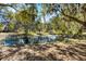 Serene pond surrounded by lush trees and landscaping at 7146 Territory Ln, Sarasota, FL 34240