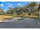 Large grassy yard with mature trees and a paved area at 7146 Territory Ln, Sarasota, FL 34240