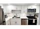 Well-lit kitchen featuring stainless steel appliances and white cabinets with marble backsplash at 7461 W Country Club Dr. N N # 106, Sarasota, FL 34243