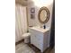 Condo bathroom with white vanity, seashell mirror, and shower at 3006 Caring Way # 409, Port Charlotte, FL 33952