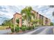 Exterior view of a condo building with palm trees and landscaping at 3006 Caring Way # 409, Port Charlotte, FL 33952