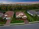 A high-angle shot of a well-manicured single-Gathering home showcases the home's brick driveway and tropical landscaping at 4611 Trento Pl, Bradenton, FL 34211