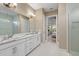 Elegant bathroom with a double vanity, marble countertop, and walk-in shower with decorative tiling at 4611 Trento Pl, Bradenton, FL 34211