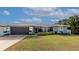 Single-story home with gray exterior, attached garage, and landscaped lawn at 6261 Keating Ave, North Port, FL 34291