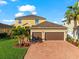 Two-story house with a two-car garage, brick driveway and palm trees at 6614 38Th E St, Sarasota, FL 34243