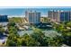 Aerial view of beachfront condo building with tennis courts nearby at 1211 Gulf Of Mexico Dr # 706, Longboat Key, FL 34228