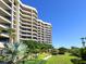 Beachfront condo building with lush landscaping and a manicured lawn at 1211 Gulf Of Mexico Dr # 706, Longboat Key, FL 34228