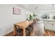 Bright dining area with wood floors, a modern table, and a view into a sunny living space at 151 Adair Ave, Sarasota, FL 34243