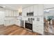 Well-lit kitchen with stainless steel appliances, white cabinetry, subway tile backsplash, and wood-look flooring at 151 Adair Ave, Sarasota, FL 34243