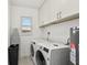 The laundry room includes a side-by-side washer and dryer and ample cabinet space at 151 Adair Ave, Sarasota, FL 34243