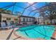 Inviting pool area with covered patio, lounge chairs, and brick coping at 151 Adair Ave, Sarasota, FL 34243