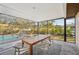 Enclosed patio featuring an outdoor dining area, seamlessly blending indoor comfort with outdoor views of lush landscaping at 151 Adair Ave, Sarasota, FL 34243