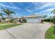 House exterior boasts a white two-car garage and palm trees at 3522 Little Country Rd, Parrish, FL 34219