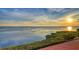 Breathtaking sunset over calm waters with lush greenery at 4557 Bay Club Dr, Bradenton, FL 34210