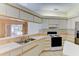 Kitchen with white cabinets, a double sink, and an electric range at 5604 Garden Lakes Dr, Bradenton, FL 34203