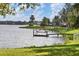 Serene lake view with a dock and lush greenery at 6503 Moorings Point Cir # 202, Lakewood Ranch, FL 34202