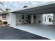 Front view of a light-colored home with carport and patio seating at 1741 Caribbean Cir # 13, Venice, FL 34293