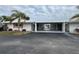 Front view of a light-colored home with carport and palm trees at 1741 Caribbean Cir # 13, Venice, FL 34293