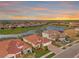 Aerial view of a luxury community with lake, sunset, and multiple homes at 20717 Benissimo Dr, Venice, FL 34293