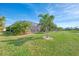 Lush green lawn with tropical landscaping and screened pool enclosure at 20717 Benissimo Dr, Venice, FL 34293