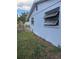 Side of house showing window and overgrown landscaping at 4951 Bell Meade Dr, Sarasota, FL 34232