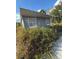 Gray storage shed with a wide overhanging roof, surrounded by tall grass at 4951 Bell Meade Dr, Sarasota, FL 34232