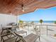 Relaxing covered balcony with outdoor seating area and stunning views of the white sand beach at 1035 Seaside Dr # 305, Sarasota, FL 34242